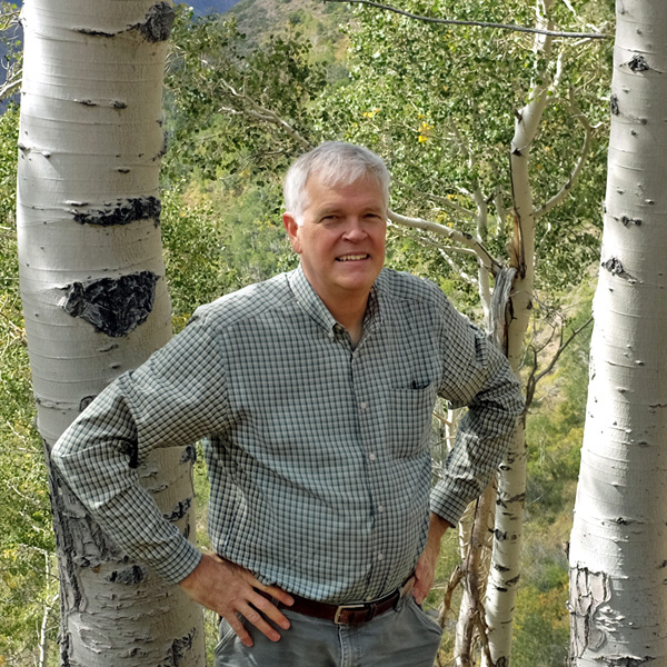 John Whitney on hill in aspen grove.